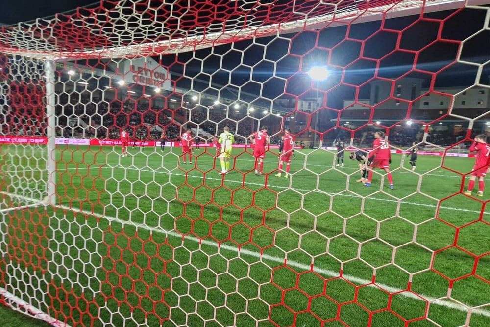A view of the Leyton Orient East Stand through the goal at the north end of Brisbane Road, during a night game